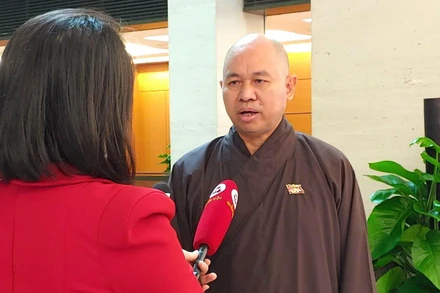 Thượng tọa Thích Đức Thiện - Đại biểu Quốc hội tỉnh Điện Biên trao đổi bên hành lang Quốc hội. (Ảnh: TRUNG HƯNG)