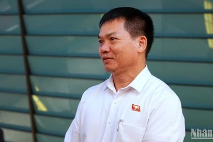 Đại biểu Dương Khắc Mai (Đoàn đại biểu Quốc hội tỉnh Đắc Nông) trao đổi bên hành lang Quốc hội. (Ảnh: TRUNG HƯNG)