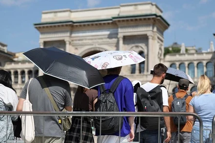 Người dân dùng ô để che nắng khi xếp hàng vào Nhà thờ Duomo trong đợt nắng nóng ở Milan, Italia, ngày 21/8/2023. (Ảnh: Reuters)