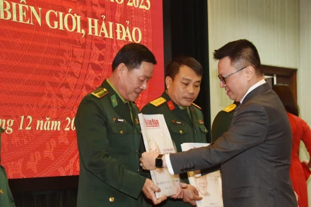 Tổng Biên tập Báo Nhân Dân Lê Quốc Minh trao tặng báo Xuân cho đại diện các đơn vị nhận báo. (Ảnh: TRẦN HẢI)