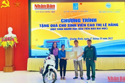 Đại diện Báo Nhân Dân và các đại biểu trao tặng xe máy, máy tính cho sinh viên Cao Thị Lệ Hằng.