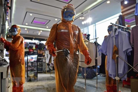 Phun thuốc khử trùng phòng dịch Covid-19 tại trung tâm thương mại ở Bình Nhưỡng, Triều Tiên. (Ảnh: Kyodo/TTXVN)