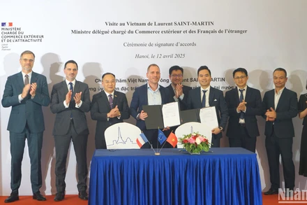 Bộ trưởng đặc trách Ngoại thương và người Pháp ở nước ngoài Laurent Saint-Martin (hàng sau, thứ 2 từ trái sang) và các đại biểu chứng kiến đại diện các doanh nghiệp hai nước ký kết thỏa thuận hợp tác. (Ảnh: TRUNG HƯNG) 