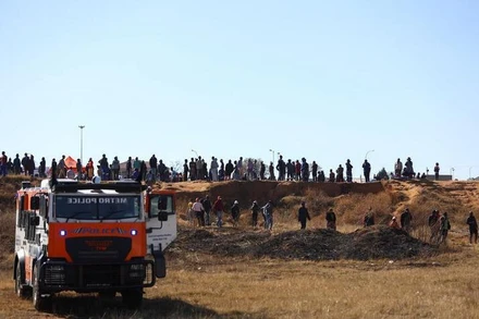 Người dân tập trung bên ngoài hiện trường vụ nổ súng ở quán bar tại thị trấn Soweto, Nam Phi, ngày 10/7/2022. (Ảnh: REUTERS)