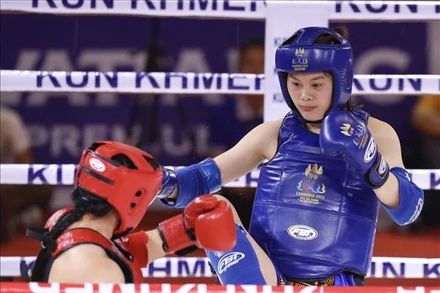 Đội Kun Khmer hứa hẹn mang về thêm nhiều tấm Huy chương Vàng quý giá trong ngày thi đấu 11/5. Trong ảnh, vận động viên Bàng Thị Mai (giáp xanh) thắng knock out Samnang Sam của nước chủ nhà Campuchia (giáp đỏ) trong trận chung kết nội dung đối kháng, hạng 60kg nữ môn Kun Khmer ngày 10/5. (Ảnh: TTXVN)