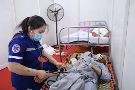 Nhân viên y tế chăm sóc người dân bị say nắng. (Ảnh: THẾ ANH)