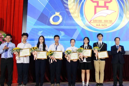 6 thành viên Đội tuyển học sinh tham dự Olympic Khoa học trẻ quốc tế năm 2024 (giữa ảnh) cùng lãnh đạo Sở Giáo dục và Đào tạo Hà Nội 