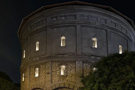 Tháp nước Hàng Đậu rực sáng vào buổi tối với những ánh đèn chiếu qua các ô cửa sổ.