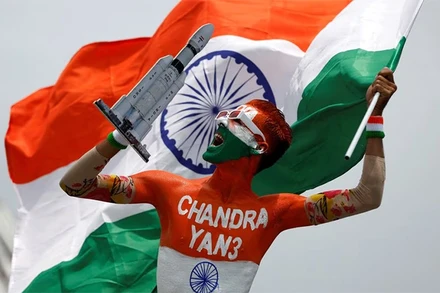 Người đàn ông Ấn Độ cầm quốc kỳ nước này và mô hình tên lửa LVM3-M4 mang theo tàu đổ bộ Chandrayaan-3. (Ảnh: Reuters)