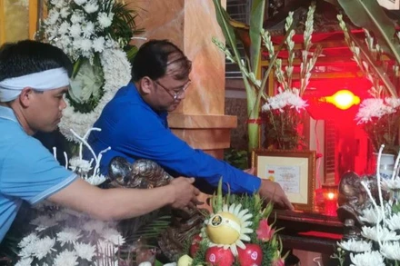 Bí thư Tỉnh đoàn Thái Bình Thiệu Minh Quỳnh đặt Huy hiệu "Tuổi trẻ dũng cảm" trước di ảnh Trung úy công an Đỗ Văn Tú. (Ảnh: Tỉnh đoàn Thái Bình cung cấp)