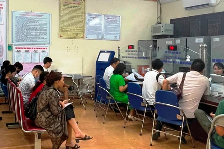 Người dân xếp hàng làm thủ tục hành chính tại huyện Thanh Trì. 