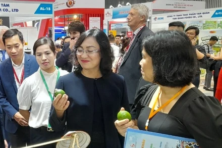 Thứ trưởng Công thương Phan Thị Thắng (giữa) tham quan sản phẩm chanh không hạt của tỉnh Long An. 