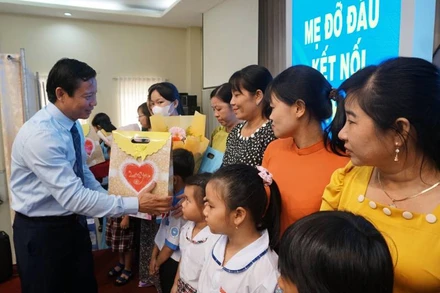 Lãnh đạo Ủy ban nhân dân tỉnh Long An trao hoa cho các mẹ đỡ đầu và quà cho trẻ mồ côi. 