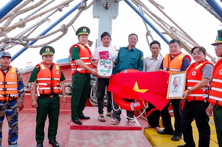 Tuần tra kiểm soát kết hợp tặng tủ thuốc Biên phòng, ảnh Bác Hồ, cờ Tổ quốc và phao cứu sinh cho chủ tàu cá.