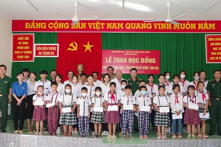 Đại diện lãnh đạo Bộ đội biên phòng tỉnh và Hội khuyến học tỉnh trao học bổng cho các em học sinh.