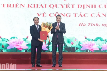 Đồng chí Lê Minh Hưng trao Quyết định của Bộ Chính trị và tặng hoa chúc mừng tân Bí thư Tỉnh ủy Hà Tĩnh Nguyễn Duy Lâm.