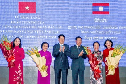 Chủ tịch nước Lương Cường và Tổng Bí thư, Chủ tịch nước Lào Thongloun Sisoulith tặng hoa chúc mừng các đồng chí được nhận Huân chương Tự do hạng Nhất.