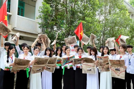 Các em học sinh Trường trung học phổ thông Công nghiệp Hòa Bình vui mừng đón nhận phụ san Báo Nhân Dân. (Ảnh: NGUYỄN TUẤN)