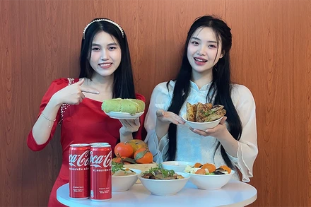 Thu Hương (phải) và bạn chụp ảnh kỷ niệm bên mâm cơm Tết. (Ảnh: nhân vật cung cấp)