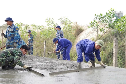 Cán bộ, chiến sĩ Lữ đoàn Công binh 131 (Quân chủng Hải quân) giúp nhân dân phường An Hồng, quận Hồng Bàng, thành phố Hải Phòng rải bê-tông mặt đê hữu sông Cấm.