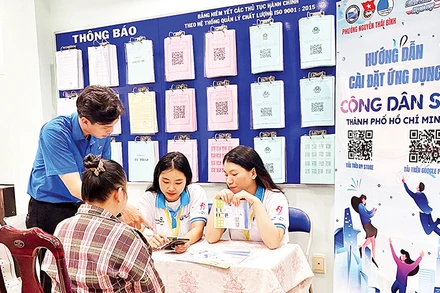 Các bạn trẻ hướng dẫn người dân Quận 1 cài đặt và sử dụng ứng dụng “Công dân số Thành phố Hồ Chí Minh”.