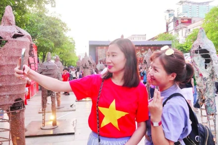 Du khách thích thú với các hoạt động trong chuỗi sự kiện “Sắc màu thành phố Bác” tại đường đi bộ Nguyễn Huệ. (Ảnh MẠNH HẢO)