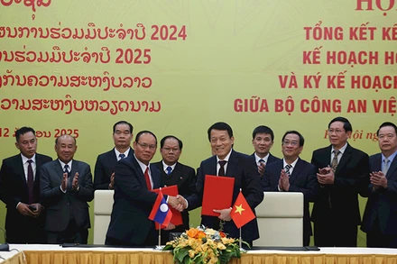 Đồng chí Lương Tam Quang, Ủy viên Bộ Chính trị, Bộ trưởng Công an Việt Nam và đồng chí Vilay Lakhamphong, Ủy viên Bộ Chính trị, Phó Thủ tướng, Bộ trưởng Công an Lào ký hợp tác giữa Bộ Công an hai nước. (Ảnh KHỔNG HÀ)