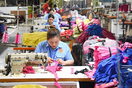 Công nhân Công ty LADODA may túi, cặp da. (Ảnh ĐỨC ANH)