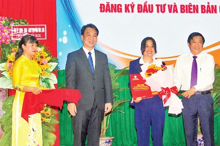 Lãnh đạo tỉnh Vĩnh Long trao giấy chứng nhận cho các nhà đầu tư. (Ảnh BÁ DŨNG)