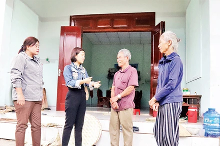 Cán bộ huyện Krông Bông và thị trấn Krông Kmar cùng vợ chồng ông Mai Văn Trung trước ngôi nhà mới có một phần kinh phí từ Quỹ tiết kiệm làm theo lời Bác.