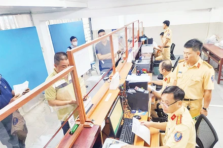 Cán bộ Cảnh sát giao thông hướng dẫn người dân, doanh nghiệp thực hiện thủ tục cấp đổi giấy phép lái xe.