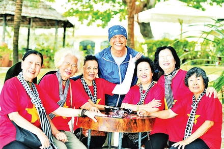 Nhiếp ảnh gia Nguyễn Á (áo xanh) chụp ảnh lưu niệm cùng các cựu tù Côn Đảo. (Ảnh CTV)