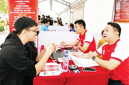 Phiên giao dịch việc làm tại quận Hà Đông thu hút nhiều người lao động đến tìm kiếm cơ hội. (Ảnh NAM DUY)