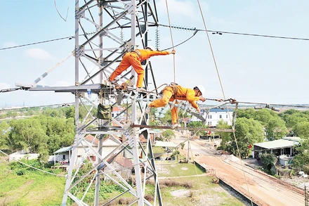 Công nhân Công ty Điện lực Quảng Bình đội nắng thi công đường dây điện 100kV. 