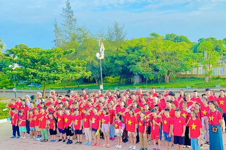 Nhóm đồng hành "Đi để hiểu" cùng cán bộ, chiến sĩ hải quân thực hiện nghi lễ chào cờ trên đảo Cồn Cỏ (Quảng Trị).