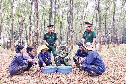 Anh Kpuih Sinh (hàng ngồi thứ tư từ trái sang), trao đổi kỹ thuật cạo mủ cao-su với công nhân.