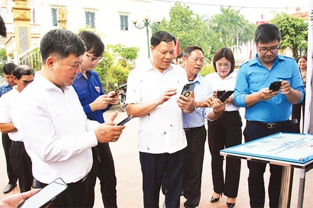 Các đại biểu thao tác quét mã QR tại đình Triều Hội.