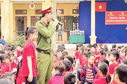 Đại úy Lương Văn Kiên tuyên truyền an toàn giao thông cho các em học sinh.