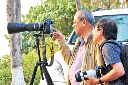 Nghệ sĩ nhiếp ảnh Trần Lam (bên trái) chia sẻ kinh nghiệm với các nghệ sĩ nhiếp ảnh cùng đi sáng tác ảnh. (Ảnh KIM ANH) 