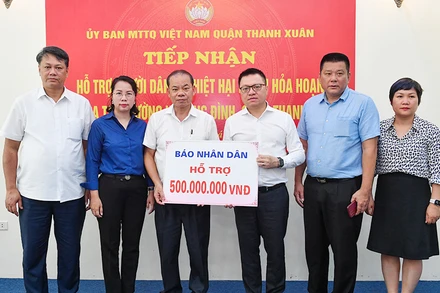 Tổng Biên tập Lê Quốc Minh cùng đoàn Báo Nhân Dân trao 500 triệu đồng hỗ trợ các nạn nhân trong vụ cháy. (Ảnh THÀNH ĐẠT)