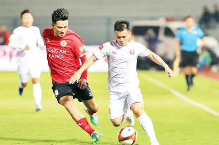 Pha tấn công của cầu thủ Hải Phòng (áo trắng) về phía đội Công an Hà Nội. (Ảnh TÙNG PHAN)