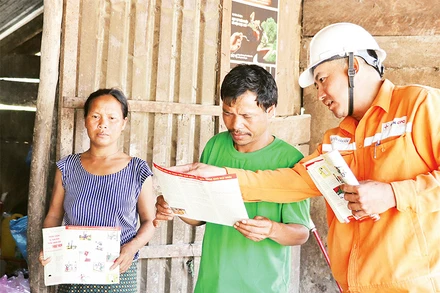 Công nhân Điện lực Quảng Bình tuyên truyền, hướng dẫn đồng bào A Rem sử dụng điện lưới an toàn.