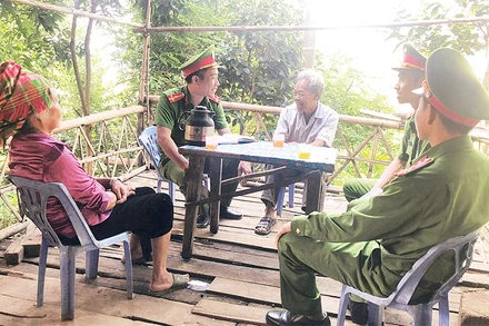 Cán bộ, chiến sĩ Công an xã Túc Đán, huyện Trạm Tấu trao đổi thông tin bảo đảm an ninh - trật tự với người dân bản Pa Khoang.