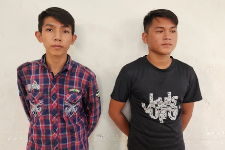 Công an đọc quyết định bắt tạm giam Nguyễn Minh Tâm (bên trái) và Trần Thanh Trọng. 