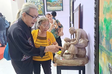 Đại biểu xem các tác phẩm được trưng bày tại triển lãm.