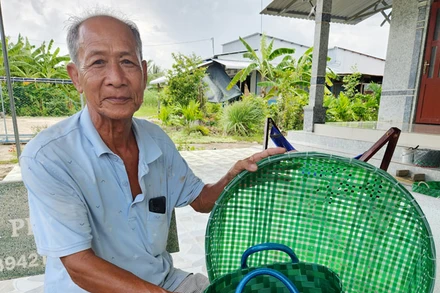 Ông Nguyễn Văn Lẹ đan dây nhựa buộc gạch thành nhiều vật dụng hữu ích. 