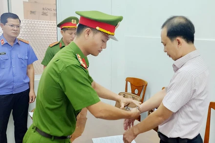 Công an tống đạt quyết định khởi tố vụ án, khởi tố bị can, ra lệnh bắt tạm giam 4 tháng đối với Hà Việt Hùng. (Ảnh: VĂN VŨ).