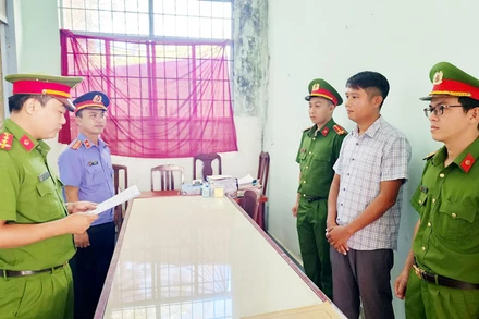 Điều tra viên tống đạt lệnh bắt tạm giam 4 tháng đối với Lê Minh Điệp (áo sơ mi sọc).