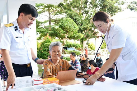 Chỉ huy Phòng Hậu cần-Kỹ thuật thăm hỏi người dân đến khám bệnh.