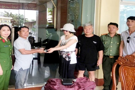 Vợ chồng du khách người Hàn Quốc (thứ 3 và 4, từ trái qua) nhận lại tài sản đã đánh rơi.